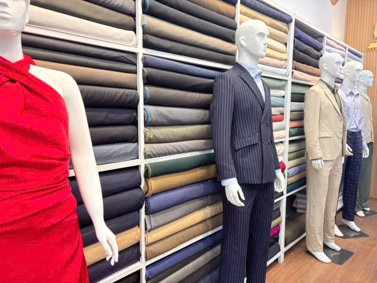 Suits, mannequins and fabrics displayed in the Le Loi atelier
